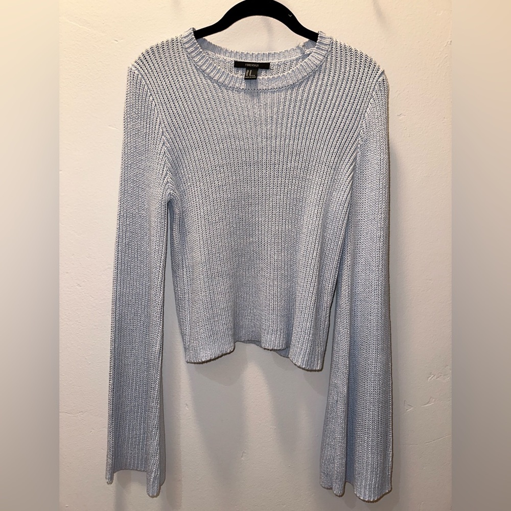 Flared sleeve cable knit sweater in baby blue.